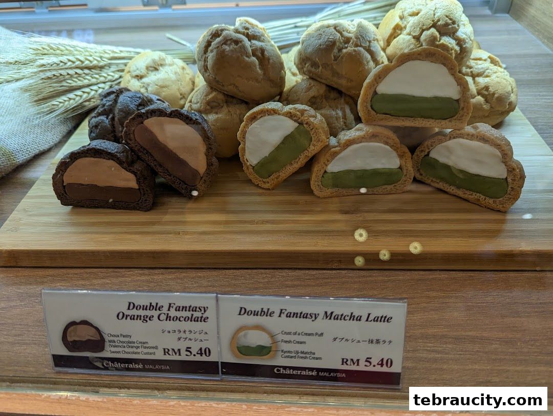 A display of delicious cream puffs, featuring orange chocolate and matcha latte flavors.