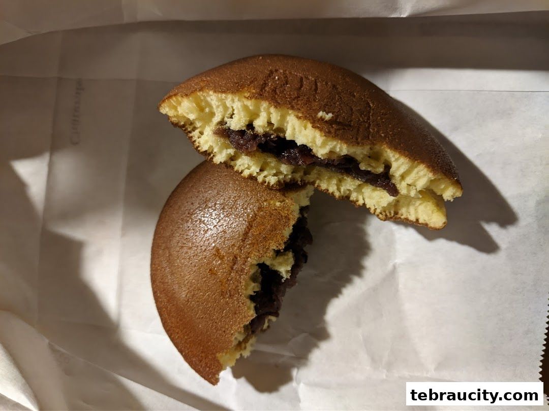 A close-up shot of a halved dorayaki, revealing its fluffy pancake and red bean paste filling.