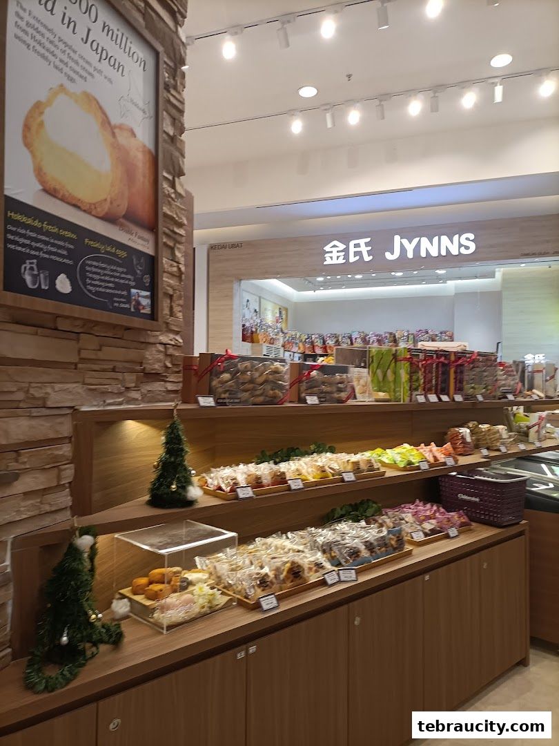 A display of various pastries and baked goods in a shop, with a sign for JYNNS.
