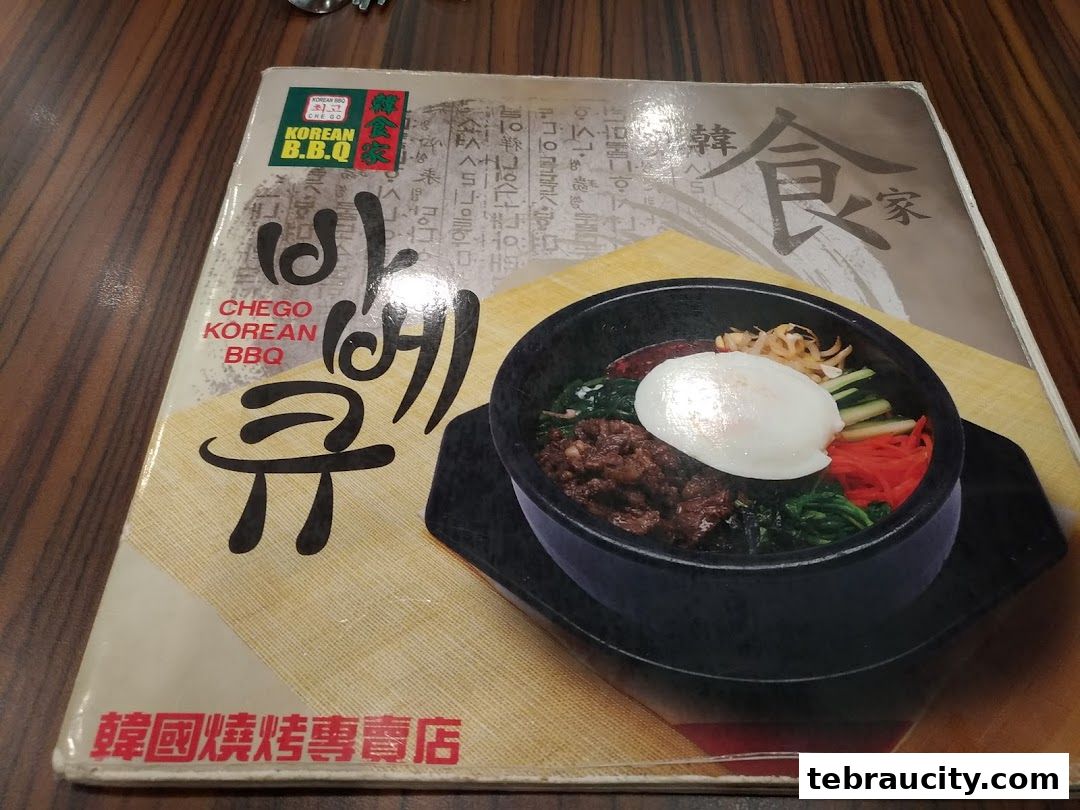 A menu cover for Chego Korean BBQ featuring a bowl of Bibimbap.