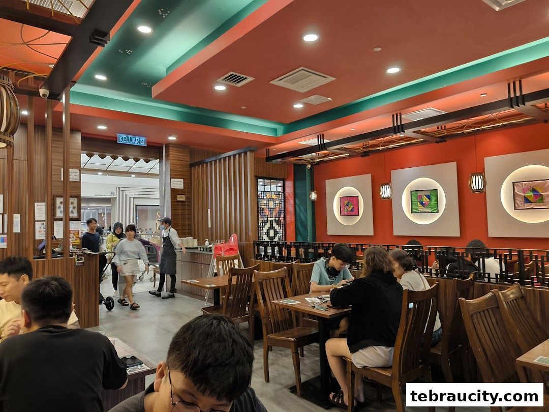 Interior view of a Korean BBQ restaurant with diners seated at tables and staff near the entrance.