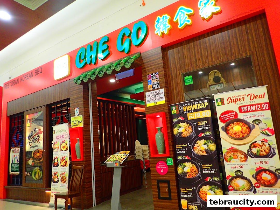 The exterior of Che Go Korean BBQ restaurant with vibrant signage and promotional banners.