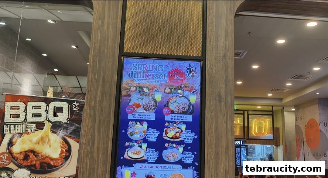 A digital menu board displaying Korean dinner sets and BBQ options at Chego Korean BBQ.