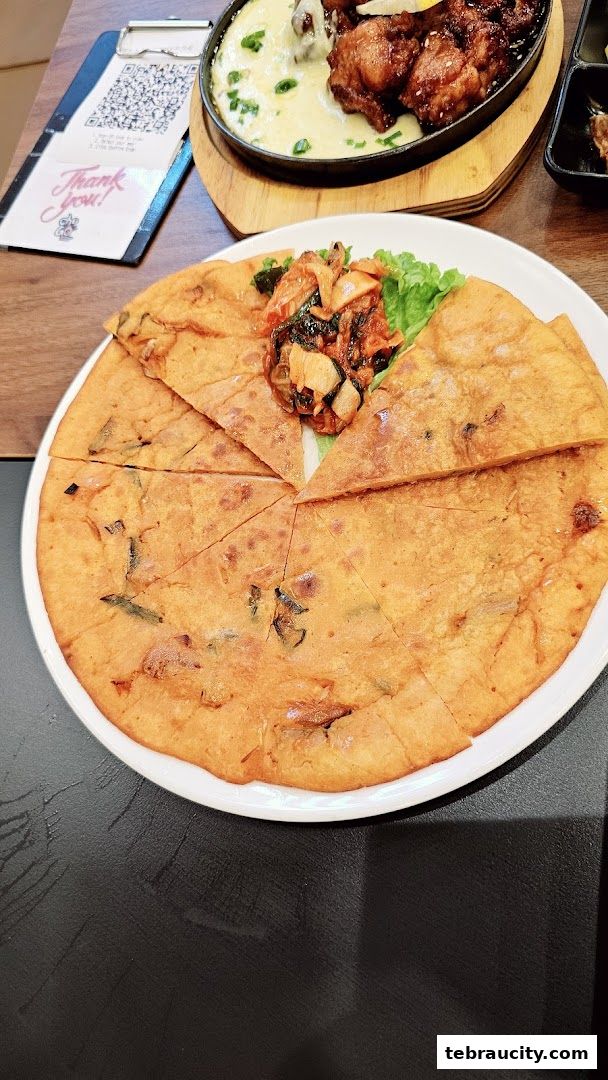 A delicious Korean pancake with kimchi and fried chicken with cheese sauce.
