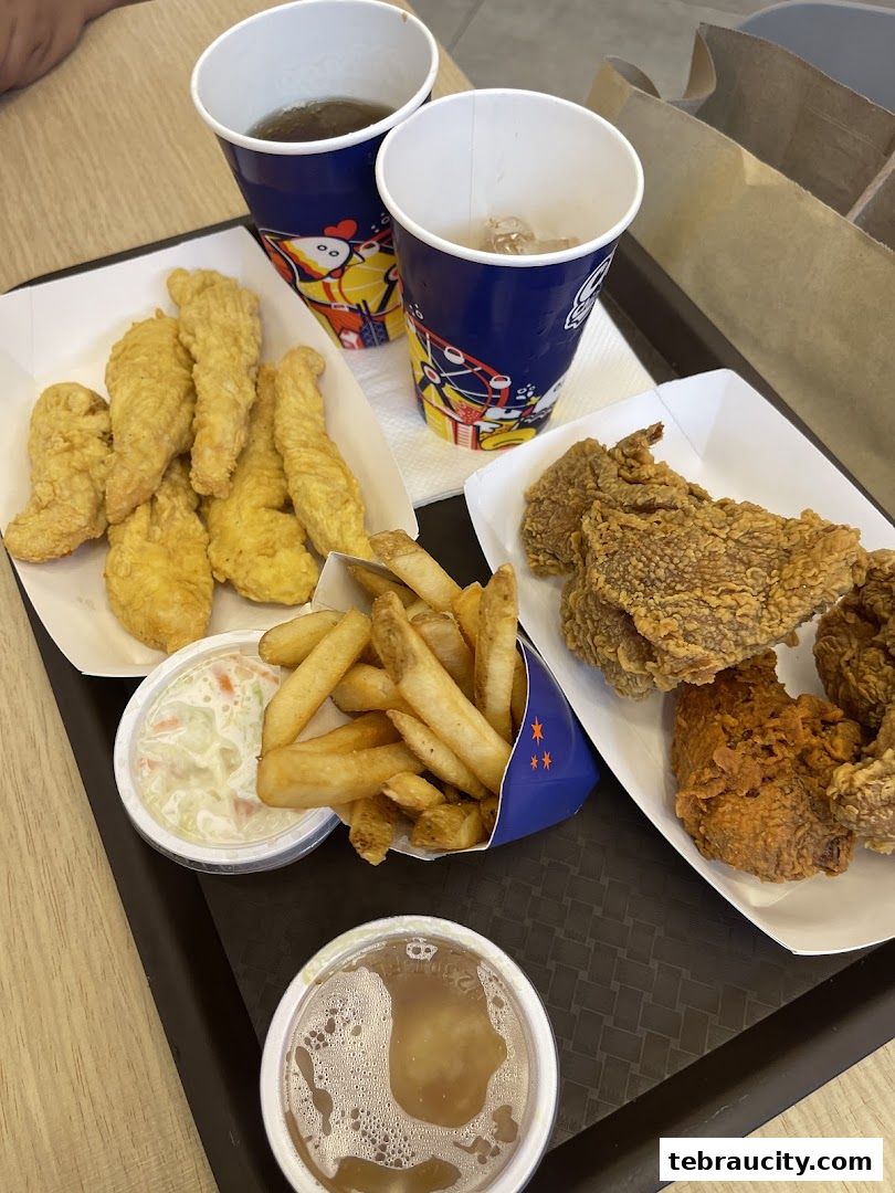 A tray of fried chicken, fries, coleslaw, and drinks from Chicago Chicken City.
