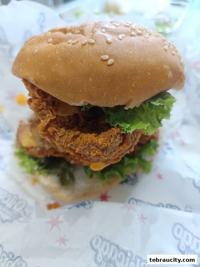 A close-up shot of a delicious double chicken burger with lettuce and cheese.