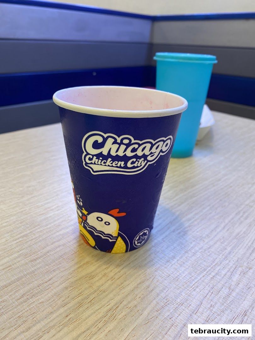 A close-up of a branded cup from Chicago Chicken City with a blue background.