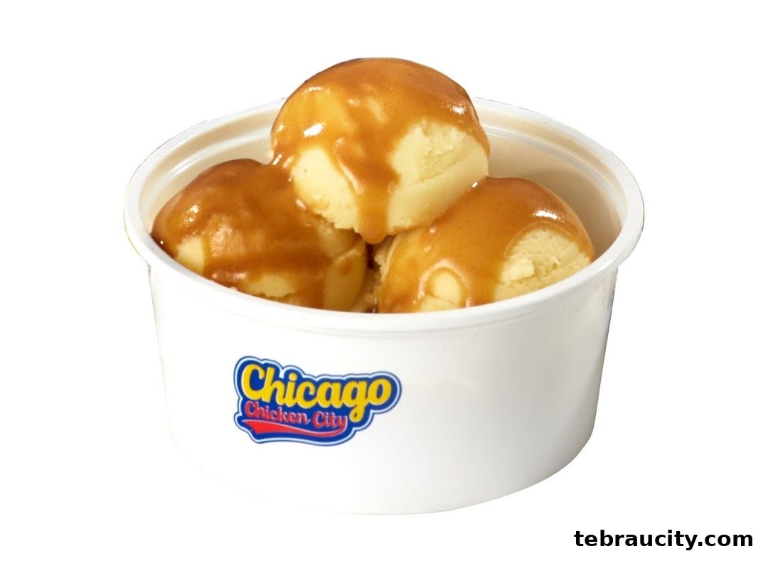 A white cup filled with three scoops of ice cream drizzled with caramel sauce.