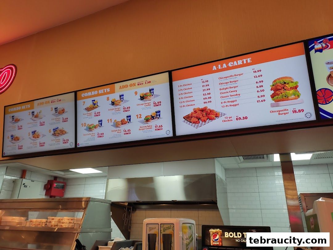 A digital menu board displaying various combo sets and a la carte chicken and burger options.