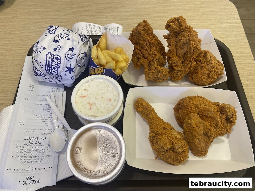 A tray of fried chicken, fries, coleslaw, a drink, and a burger from Chicago Chicken City.