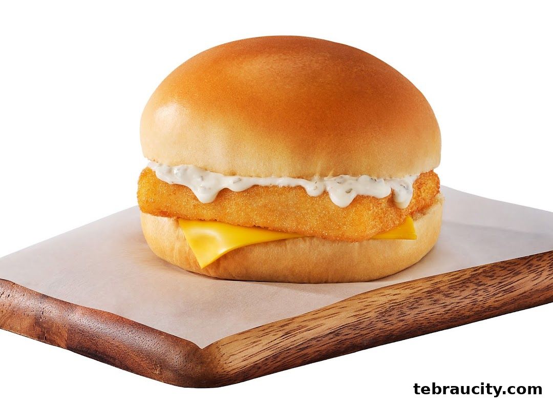 A close-up shot of a delicious fish sandwich with cheese and tartar sauce.