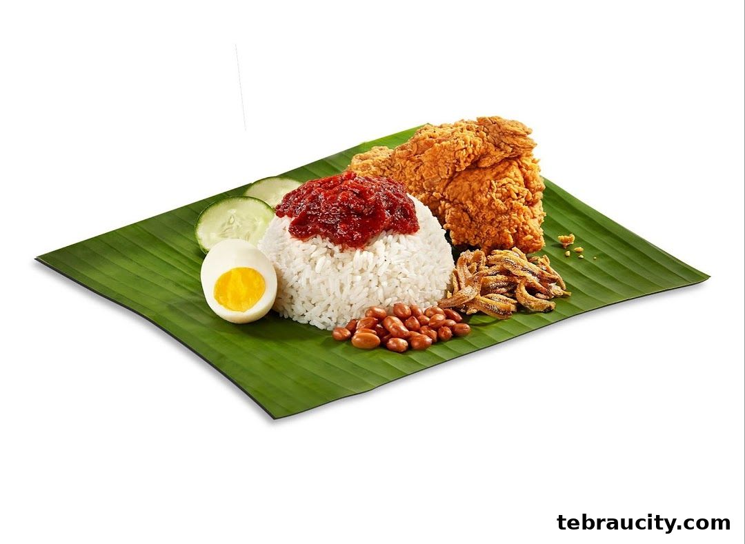 A plate of Nasi Lemak with fried chicken, egg, peanuts, anchovies, and sambal on a banana leaf.