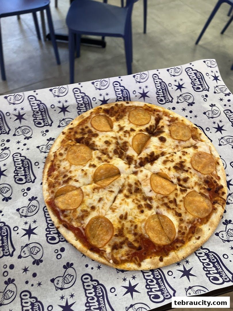 A close-up shot of a pepperoni pizza served on branded paper at Chicago Chicken City.