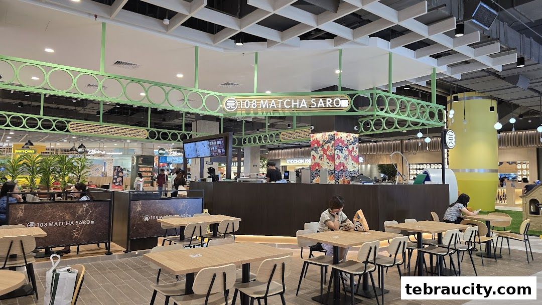 Interior view of a modern food court with tables and chairs, featuring the '108 Matcha Saro' shop.