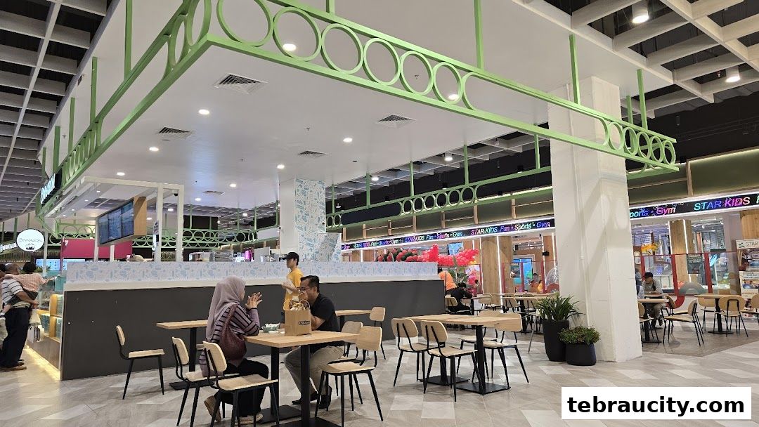Interior view of a Cinnabon shop with seating area and other shops in the background.