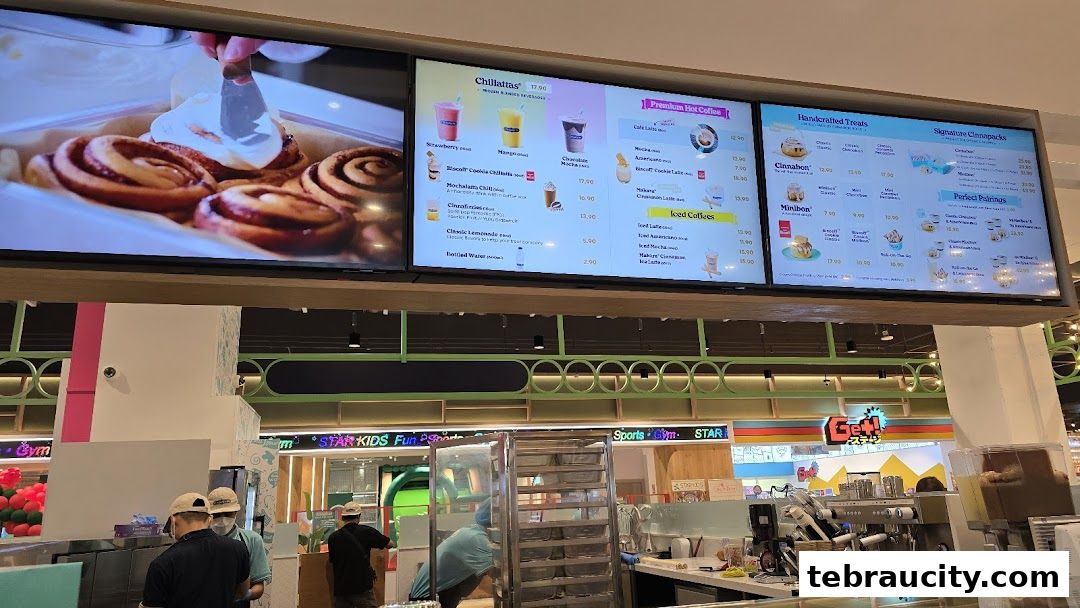 A digital menu board displaying Cinnabon's signature treats and beverages.