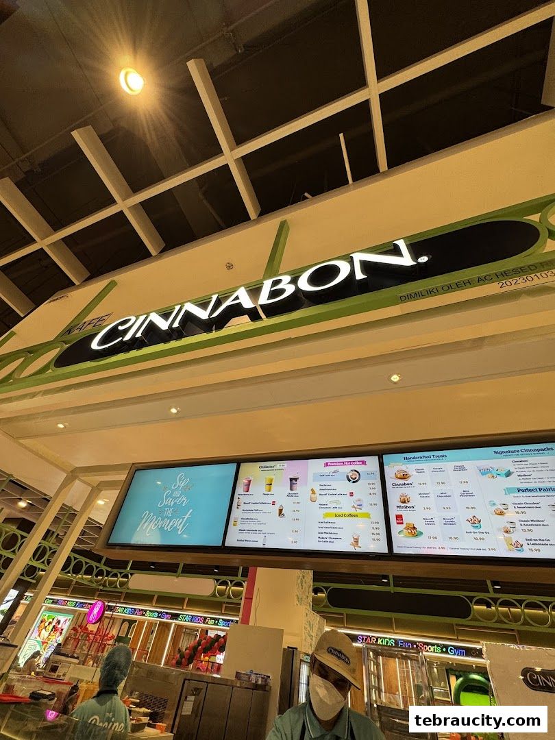 A digital menu board displaying Cinnabon's offerings, including drinks and treats.