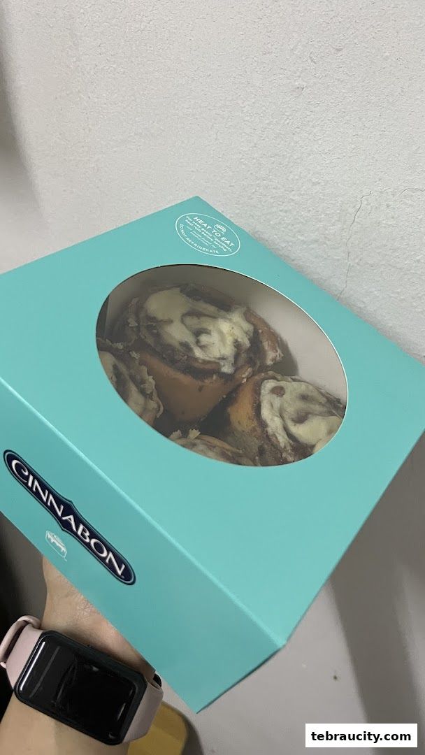 A Cinnabon box filled with freshly baked cinnamon rolls.