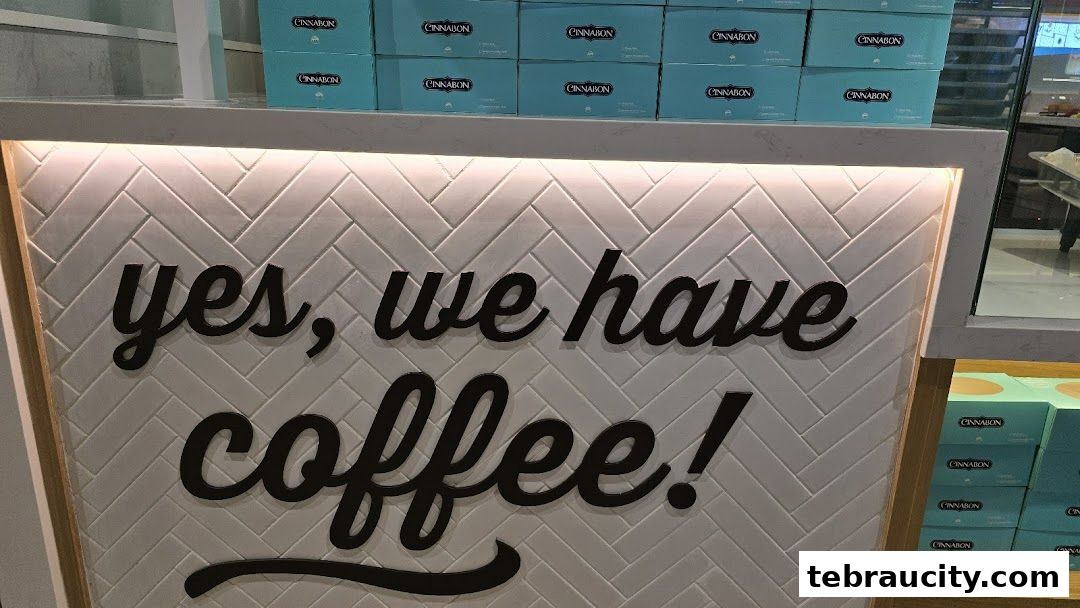 A Cinnabon counter with a sign saying 'yes, we have coffee!' and boxes stacked behind.