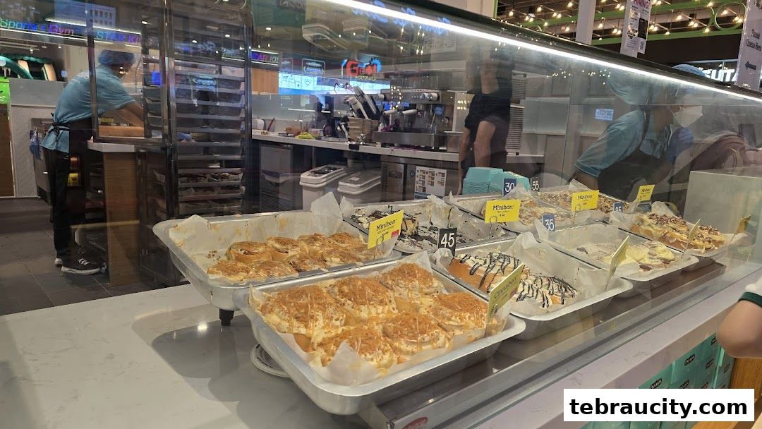 A display of freshly baked cinnamon rolls at Cinnabon, with staff preparing them in the background.