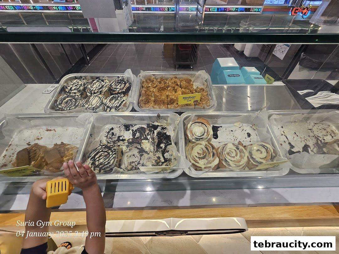 A display case filled with various cinnamon rolls and baked goods.