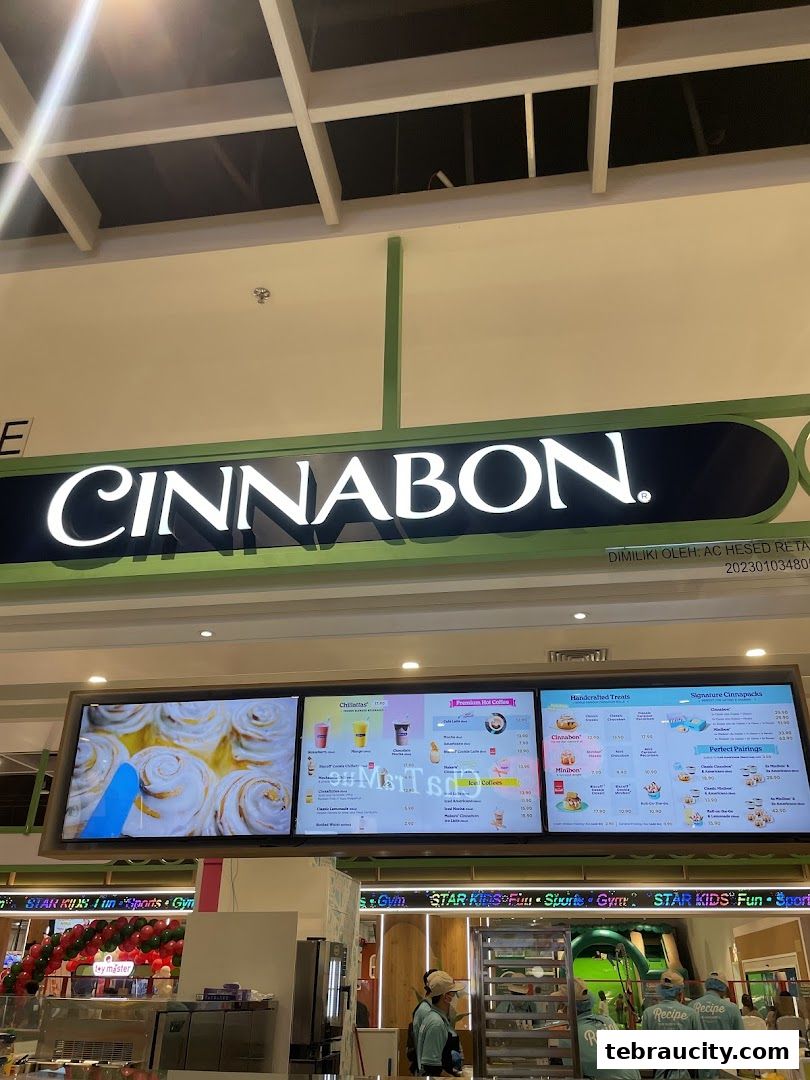 The Cinnabon store sign and digital menu board displaying various sweet treats and beverages.