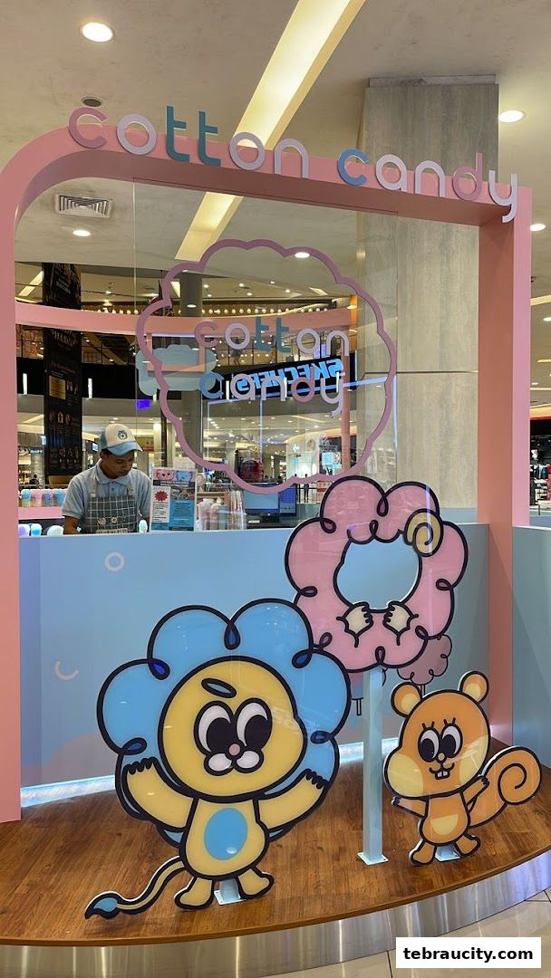 A brightly decorated Cotton Candy shop with cartoon characters and a staff member behind the counter.