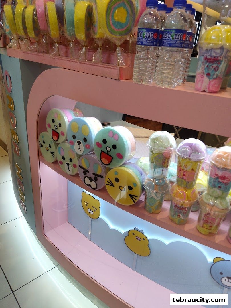 A display of colorful cotton candy, bottled water, and sweet treats in cute packaging.