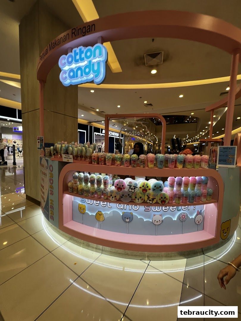 A colorful cotton candy stall in a shopping mall with various sweet treats on display.