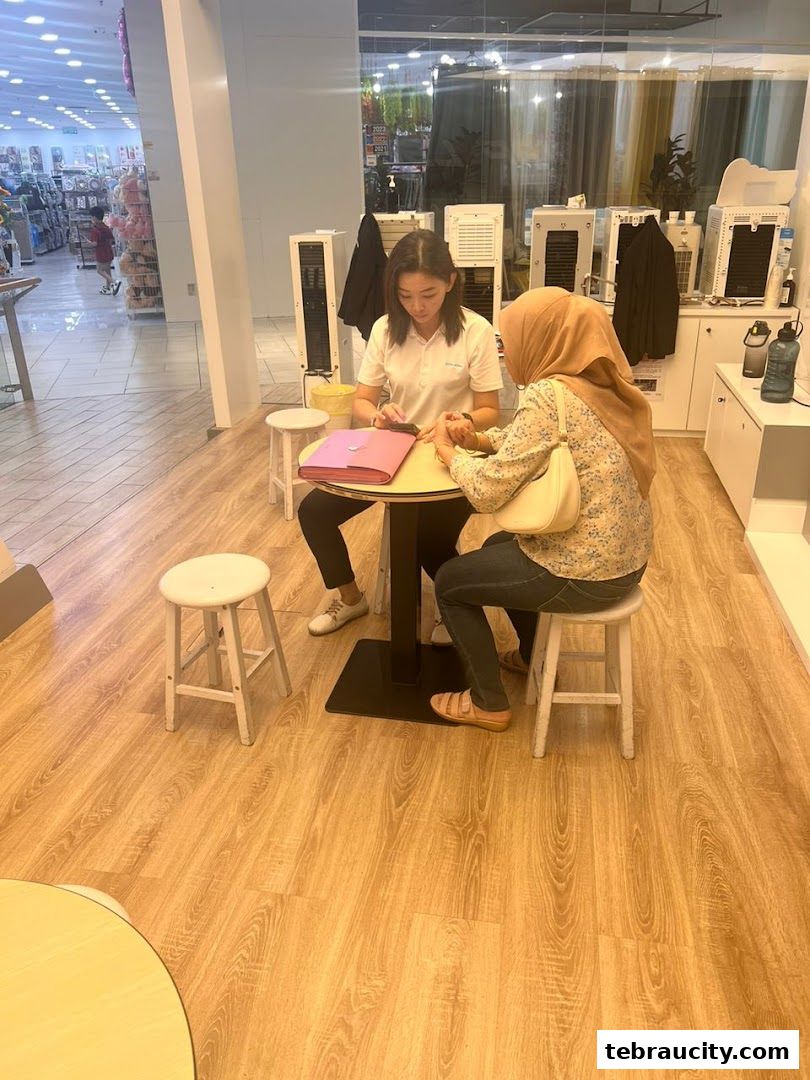 A staff member provides a nail service to a customer at a table.