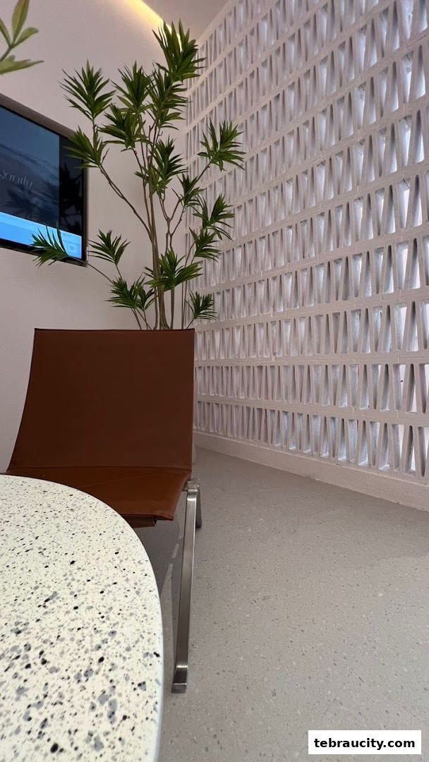 A modern waiting area with a brown chair, plant, and decorative wall.