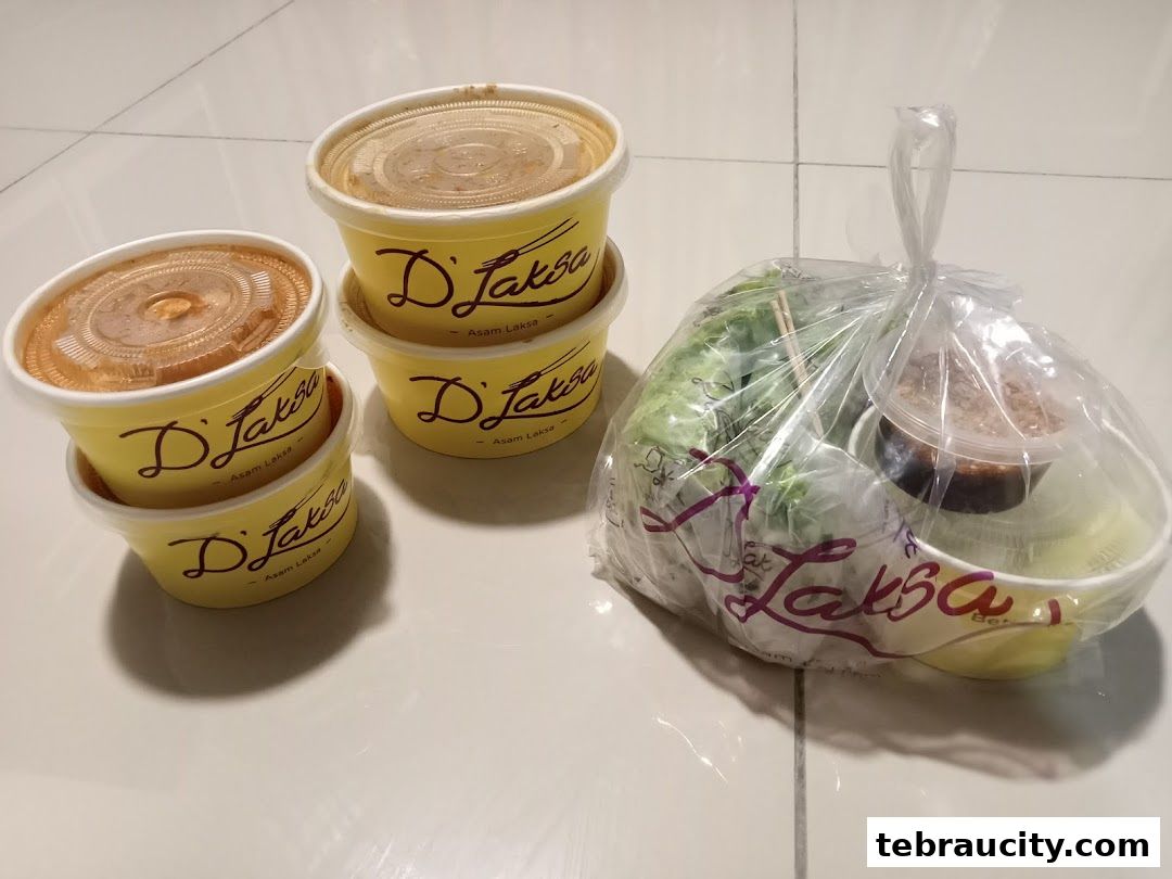 Takeaway containers and a plastic bag with food from D Laksa.