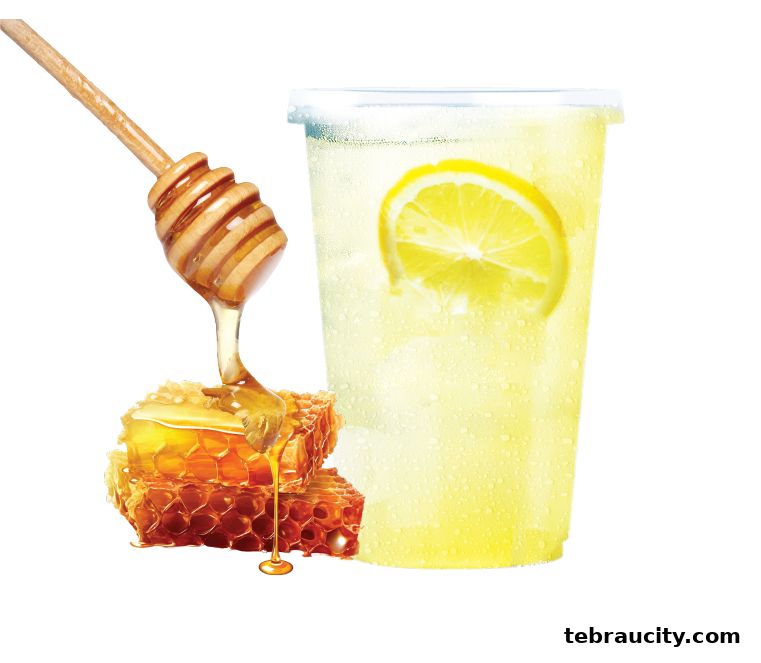 A refreshing honey lemon drink with honeycomb and a honey dipper.