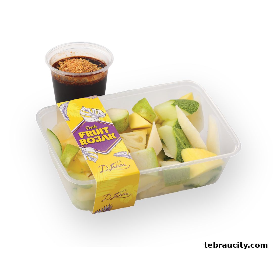 A container of fresh fruit rojak with a side of dipping sauce.