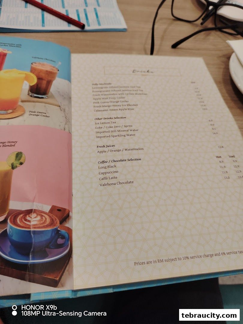 A menu from Dolly Dim Sum featuring drinks like mocktails, fresh juices, and coffee selections.