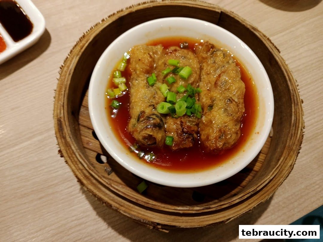 A close-up of delicious dim sum served in a bamboo steamer with dipping sauce.