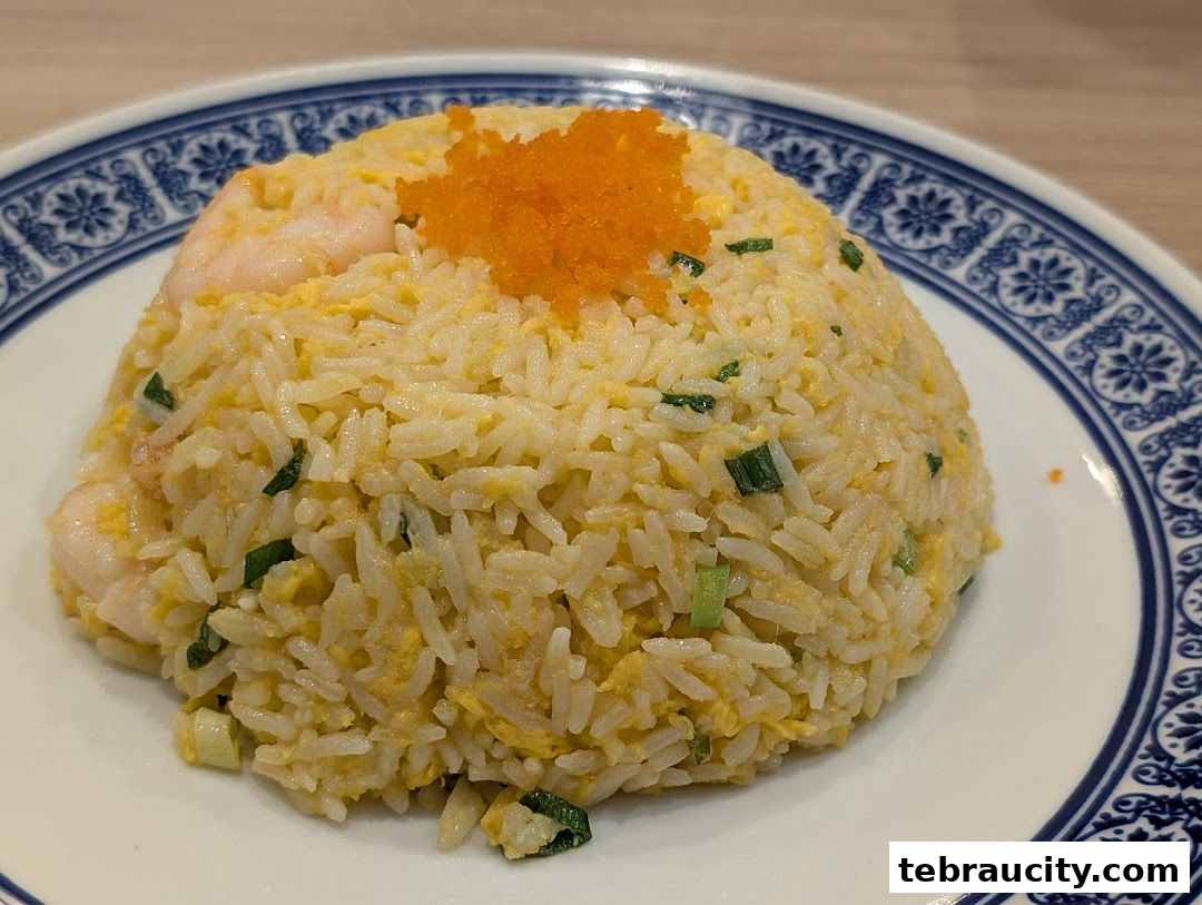 A close-up of a delicious shrimp fried rice dish topped with tobiko.