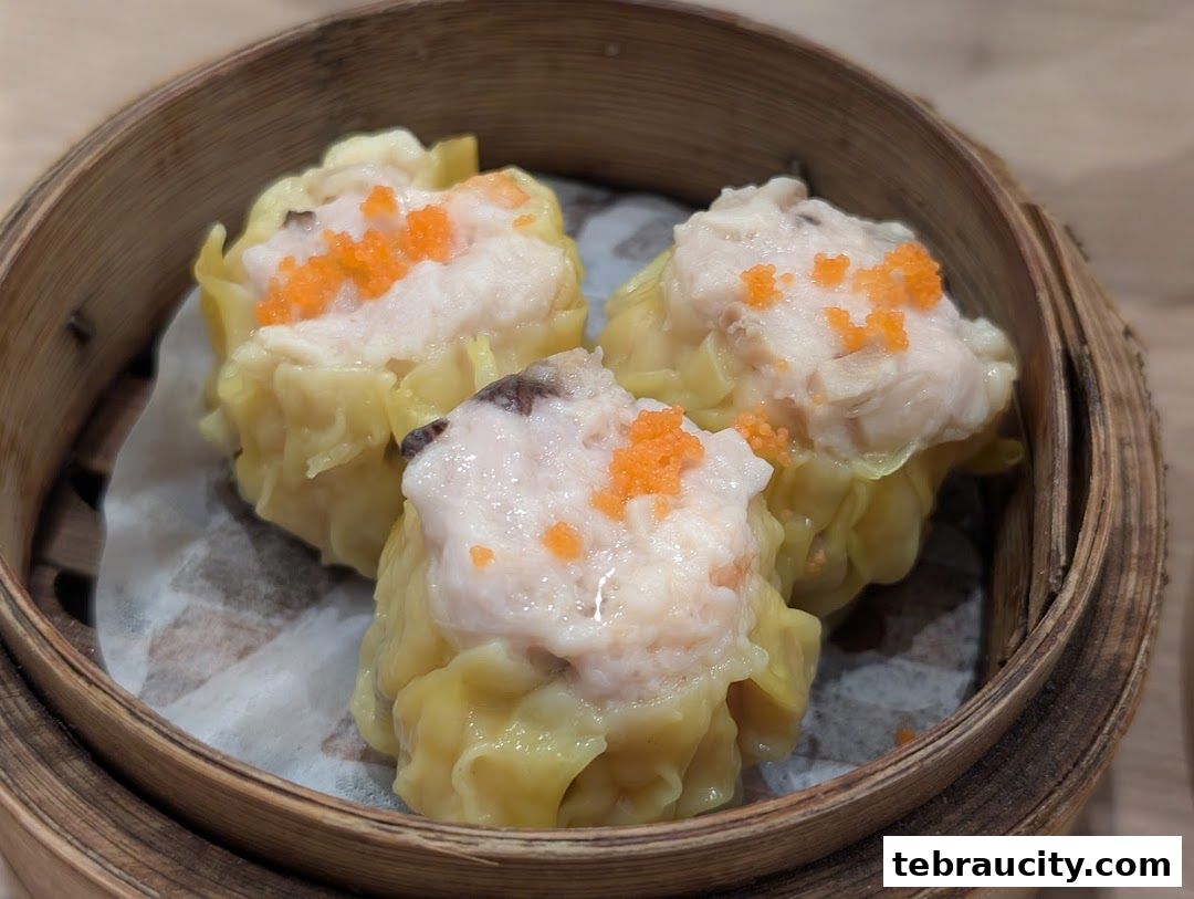 Close-up of three delicious dim sum dumplings in a bamboo steamer.