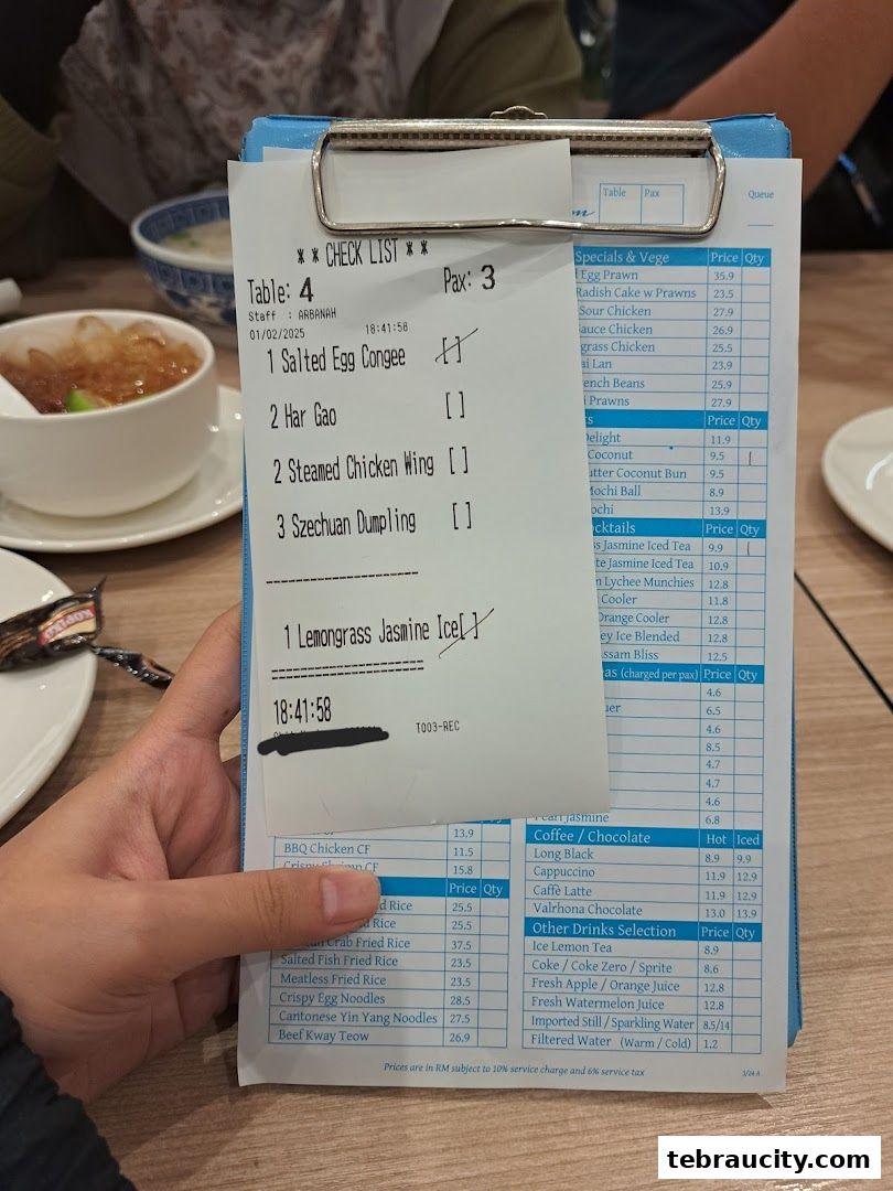 A person holding a check list with various dim sum and drink items with prices.