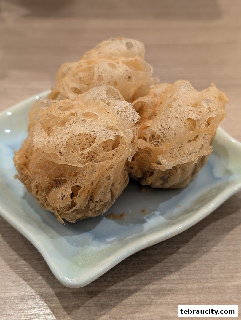Three crispy, golden-brown dim sum items served on a light blue plate.
