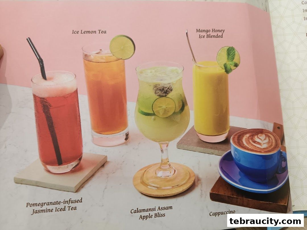 A selection of colorful beverages and a cappuccino are displayed on a pink and white background.