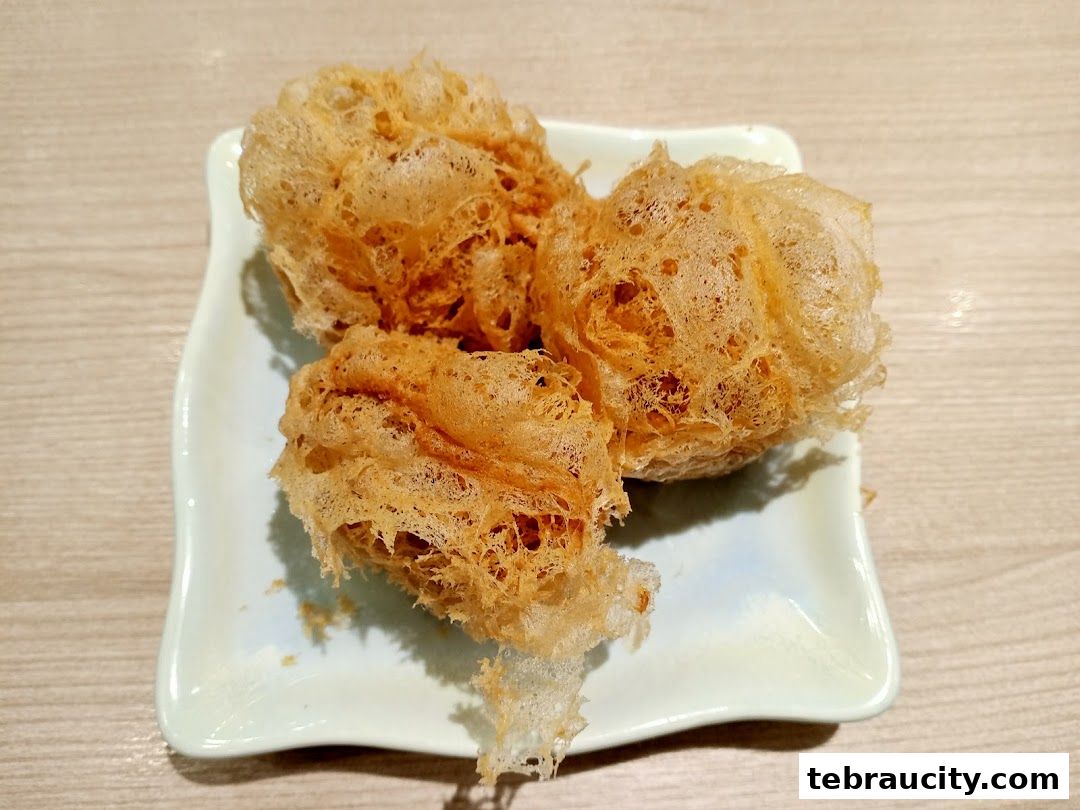 Three crispy, golden-brown dim sum items served on a light blue square plate.