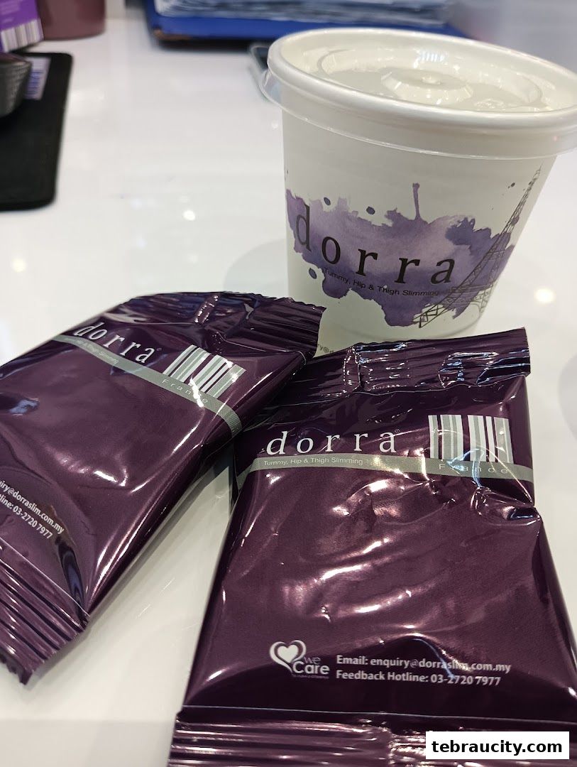 Two purple Dorra slimming product packages and a branded cup.