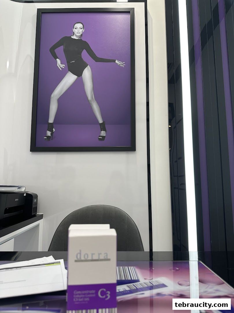 A framed image of a woman in a slimming outfit and a product box on a desk.