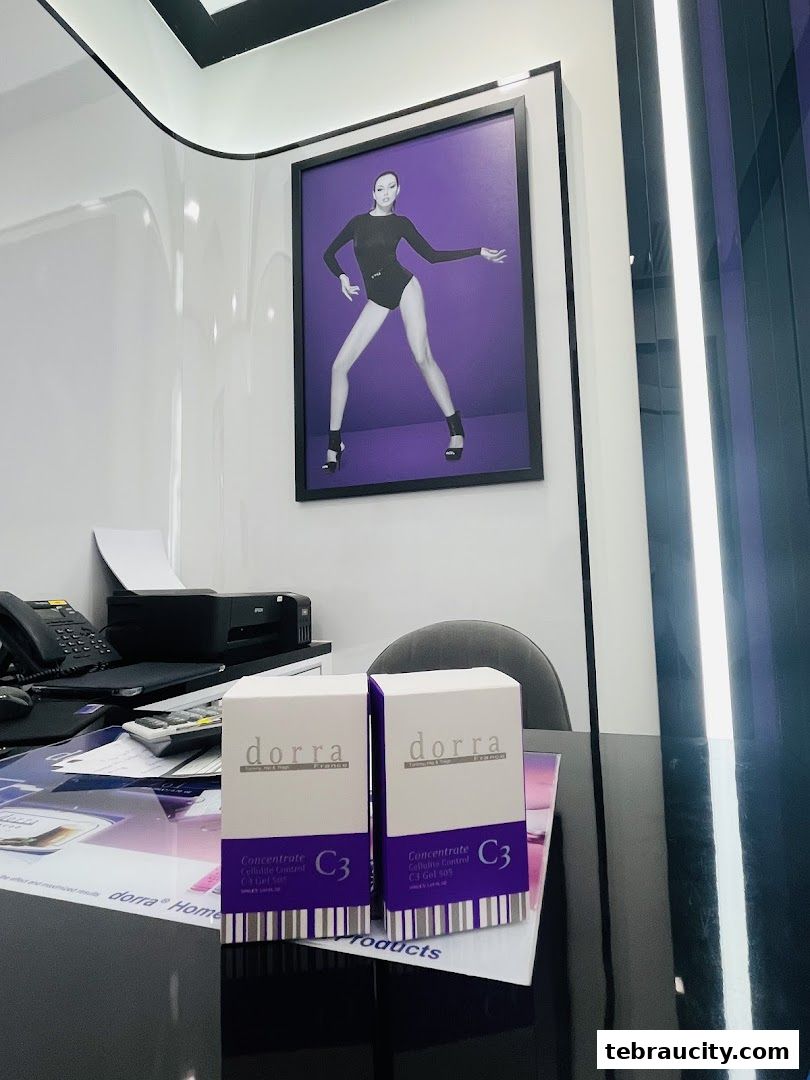 Two boxes of Dorra Slimming Concentrate C3 Gel are displayed on a desk with a framed picture of a model.
