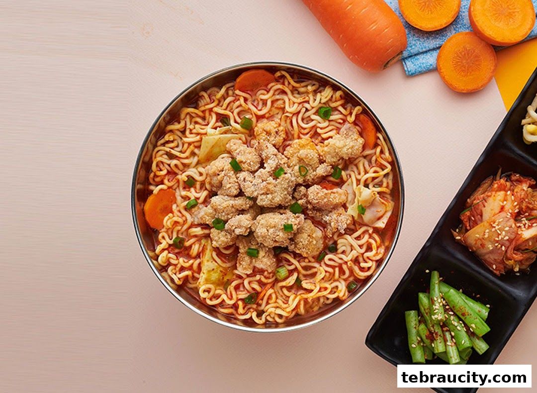 A bowl of Korean ramen with fried chicken, carrots, and kimchi.