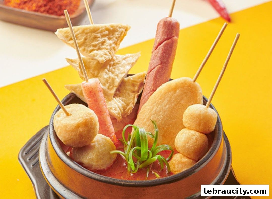 A close-up of a bowl filled with various Korean street food skewers in a savory broth.