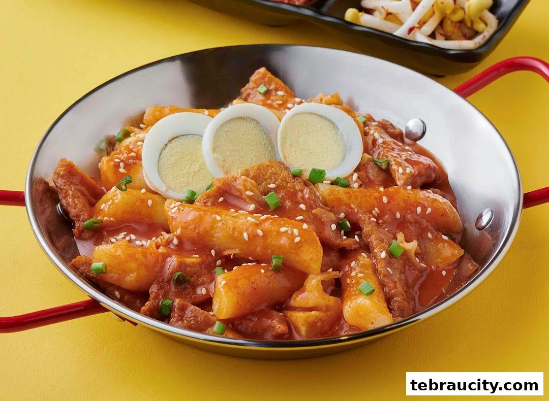 A close-up of a delicious Korean Tteokbokki dish with boiled eggs and sesame seeds.