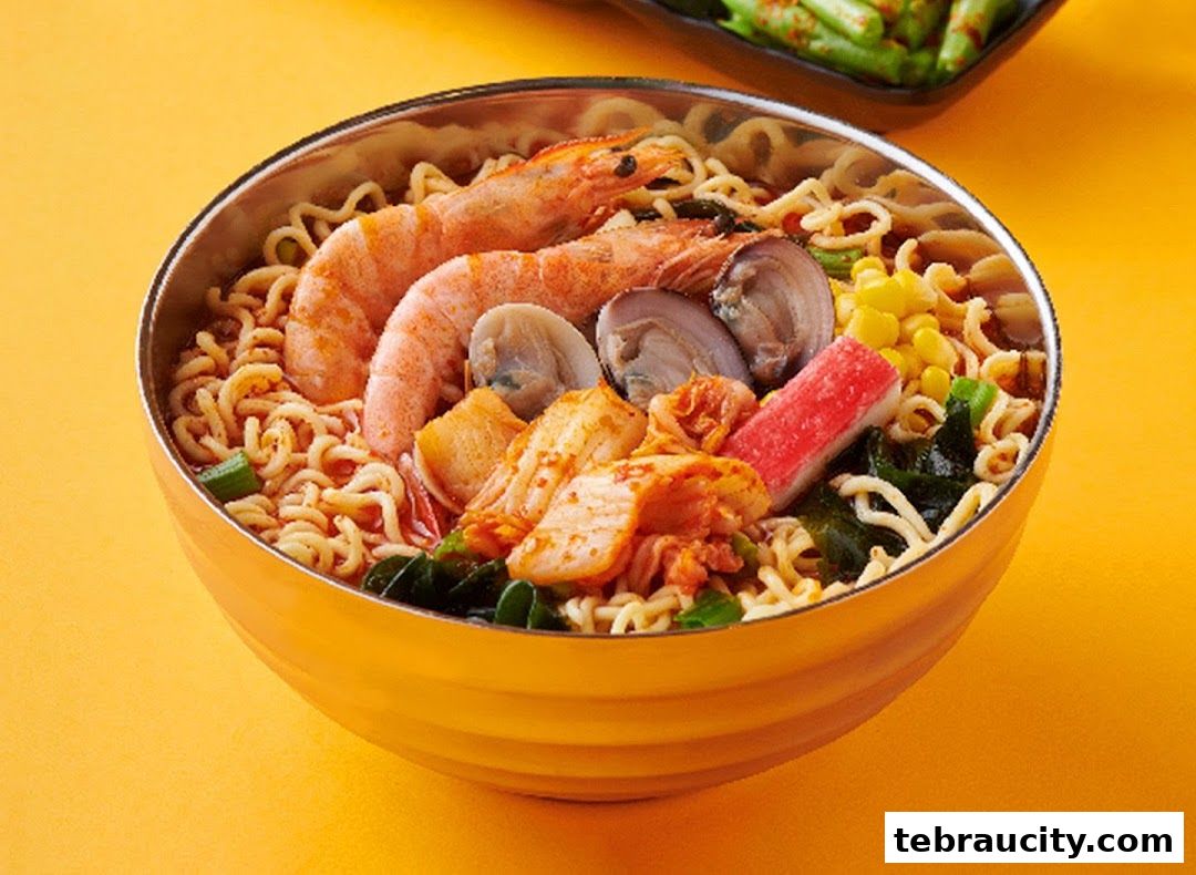 A close-up of a steaming bowl of ramen with shrimp, clams, kimchi, and other toppings.