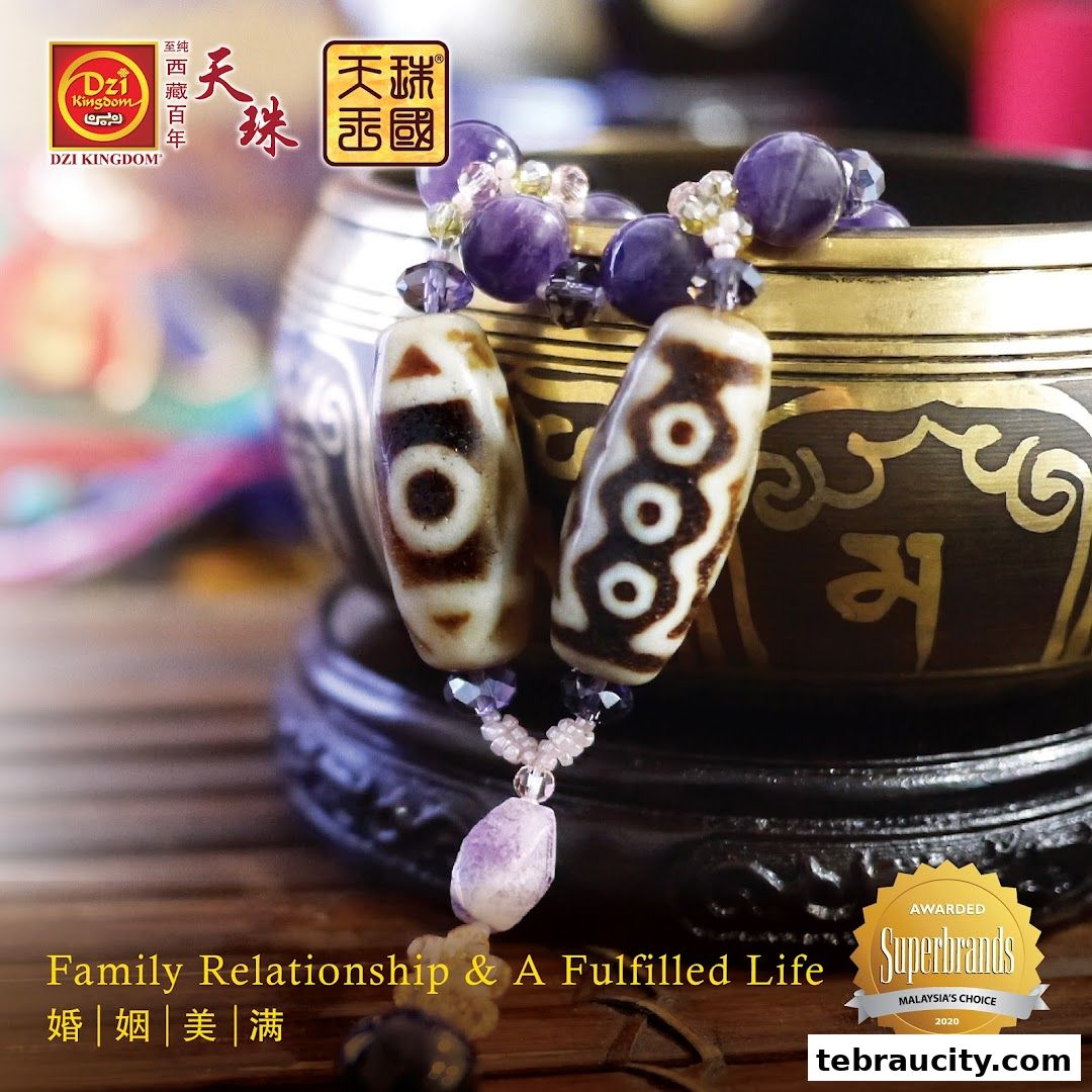 Close-up of Dzi beads and amethyst bracelet with a decorative bowl.